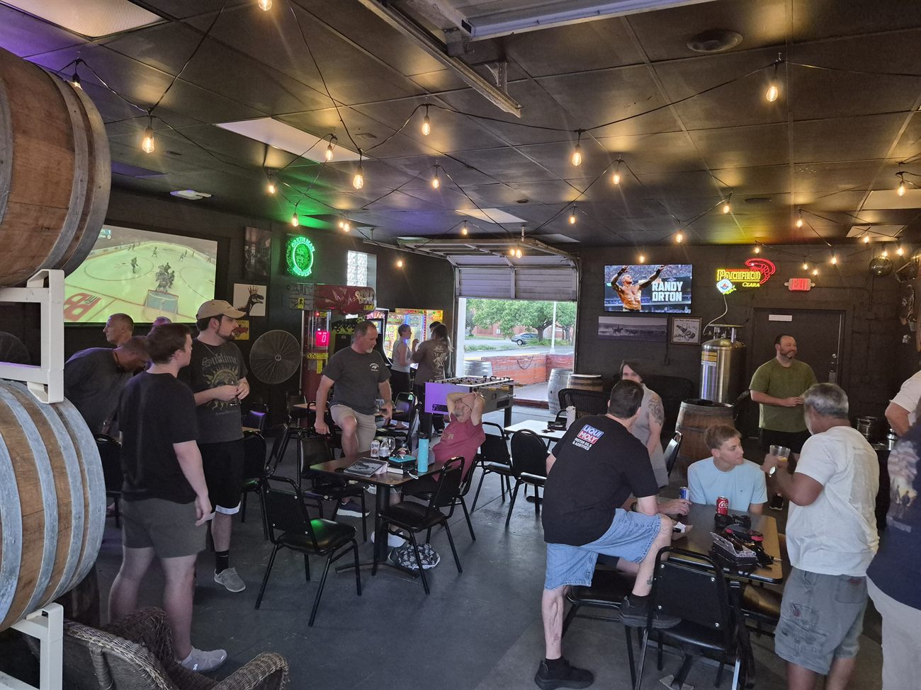 Guests watching sports and playing foosball at Southern Range Brewing