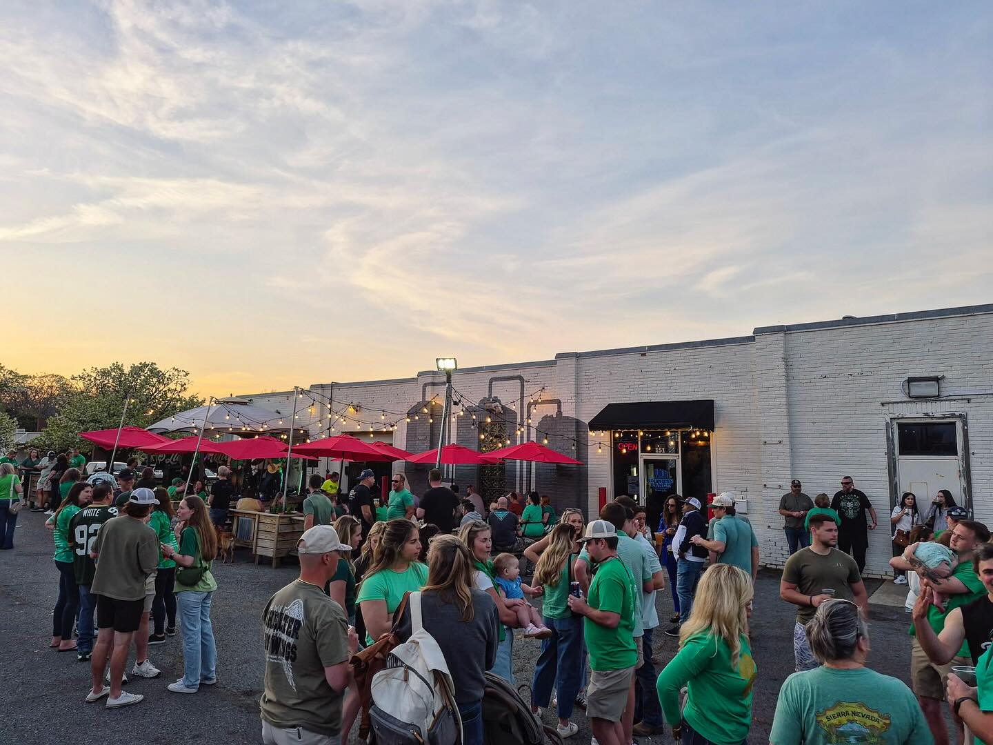 Crowd enjoying craft beer at sunset outside Southern Range Brewing in downtown Monroe, NC
